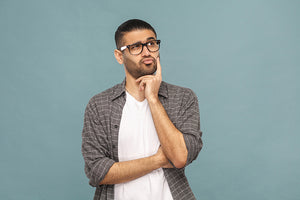 A man with eyeglasses is deep in thought.